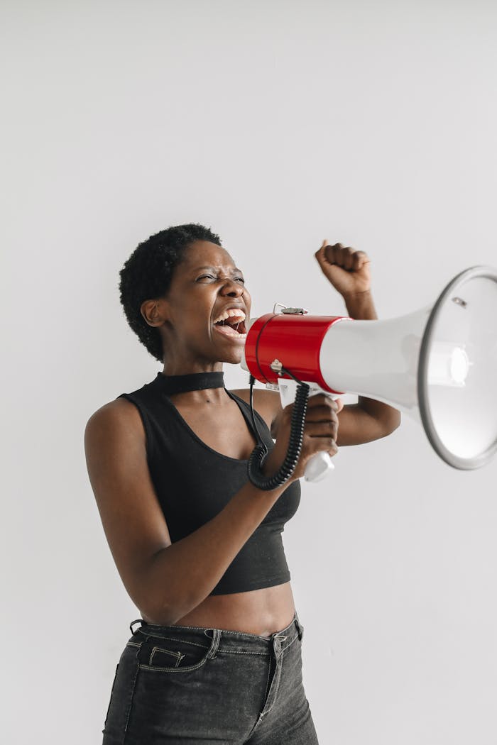 An inspired woman energetically uses a megaphone during a protest, symbolizing activism and empowerment.